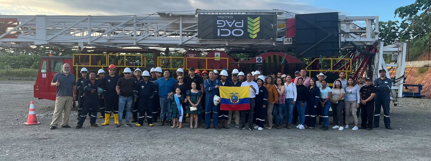 Personal de SAGNAYOIL S.A. reunido frente a un equipo de perforación en la Amazonía ecuatoriana, con la bandera del Ecuador